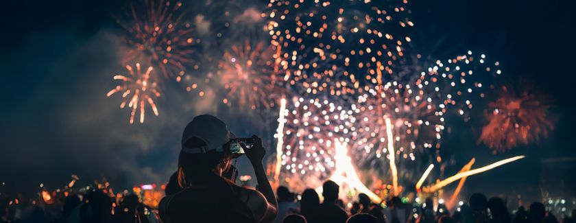 Woman taking photo of 4th of July fireworks.