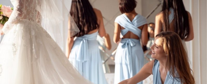 bride and bridesmaids fixing dress